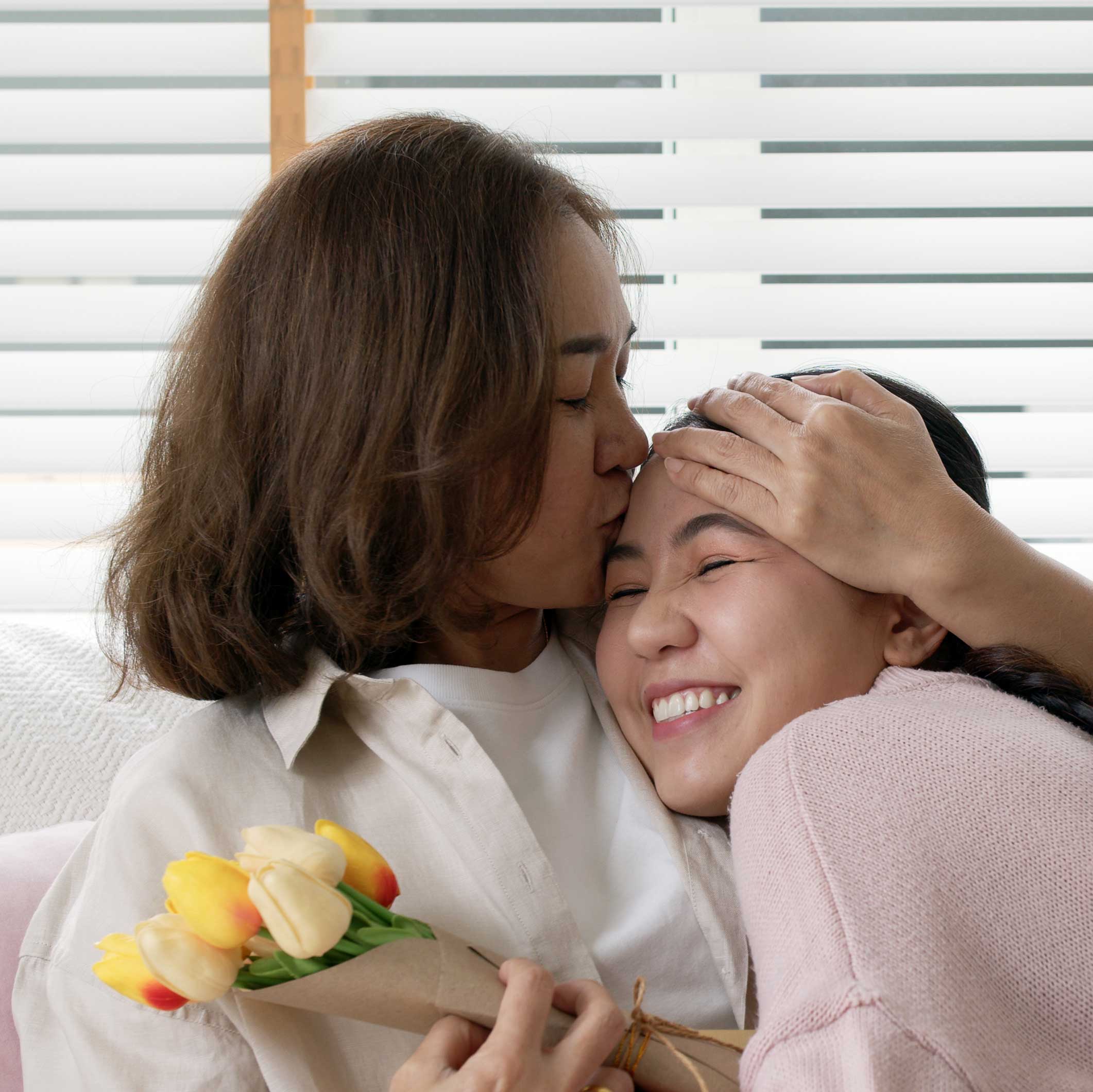 a woman and her daughter hugging and smiling