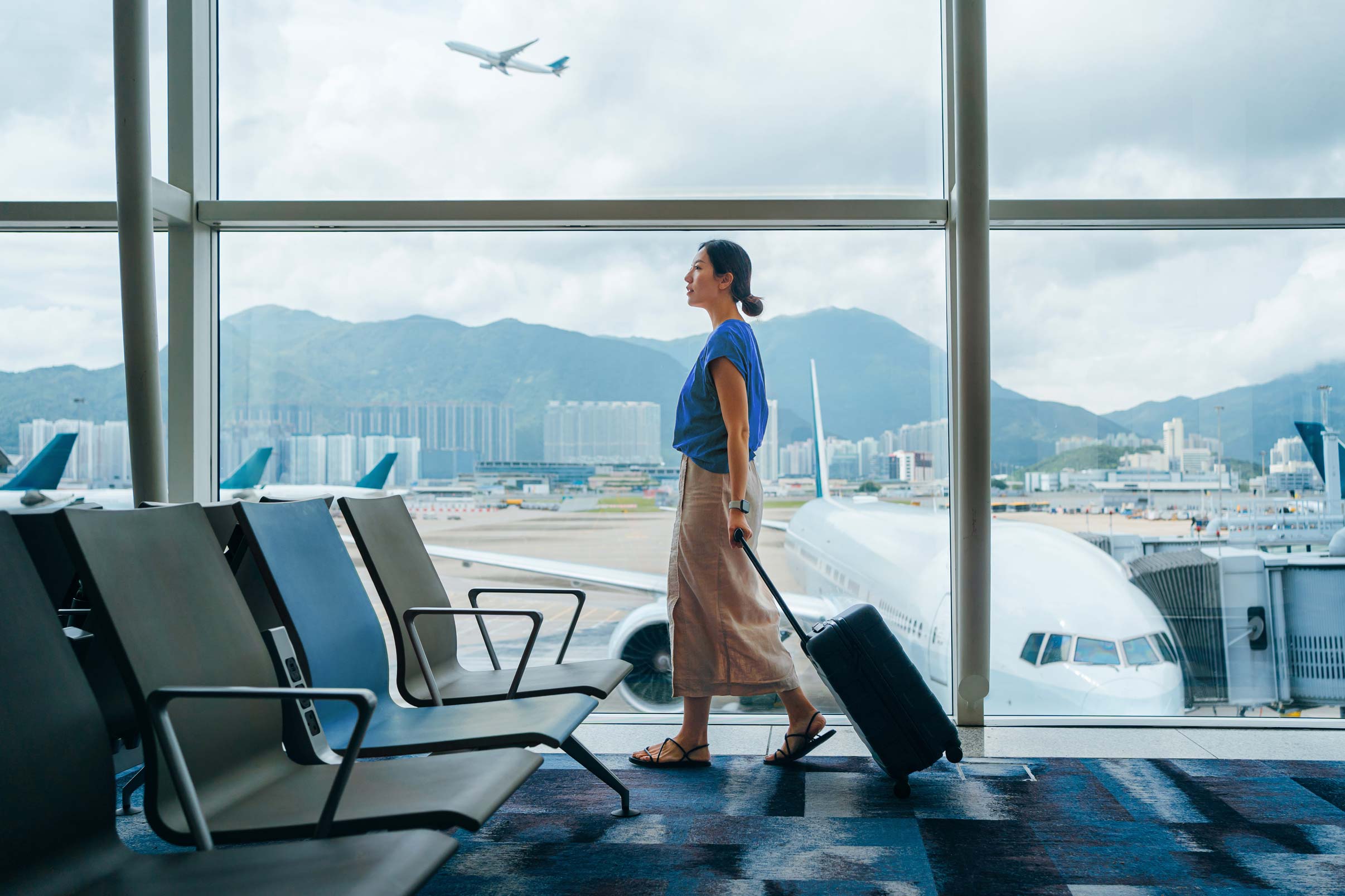 Woman walking with luggage at an airport