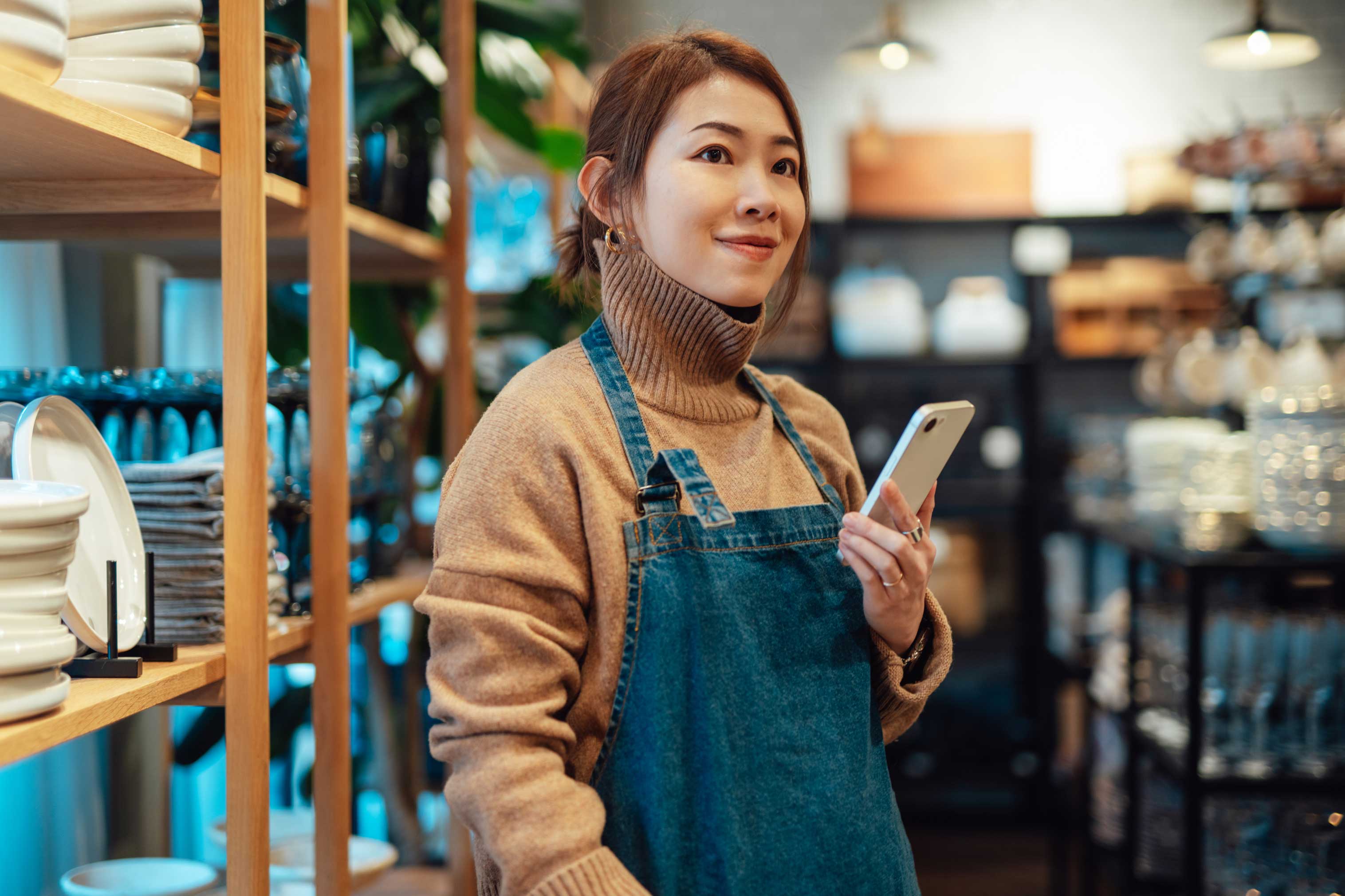 woman holding phone in a ceramics shop